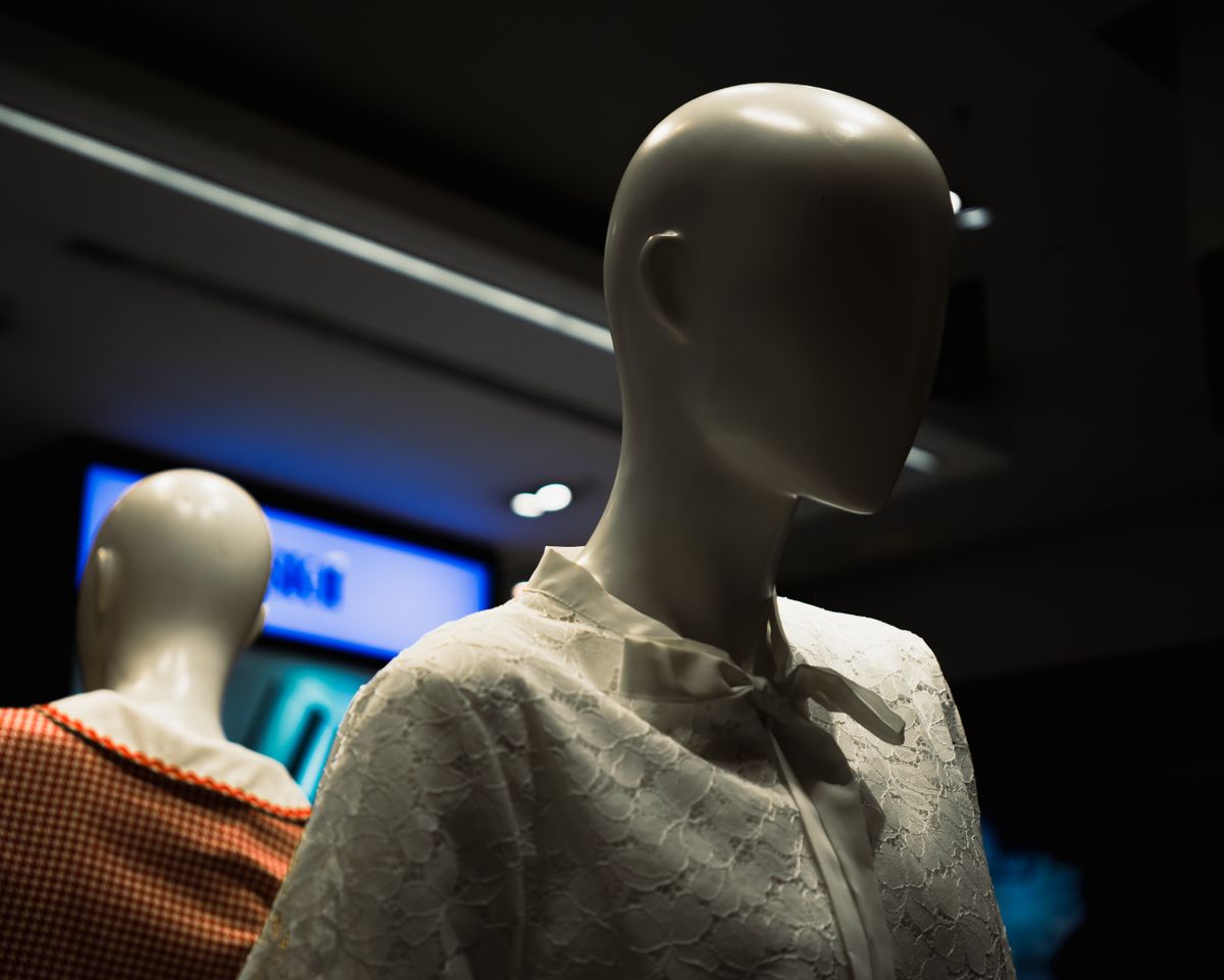 Faceless mannequins displaying different bra and clothing styles in a shop
