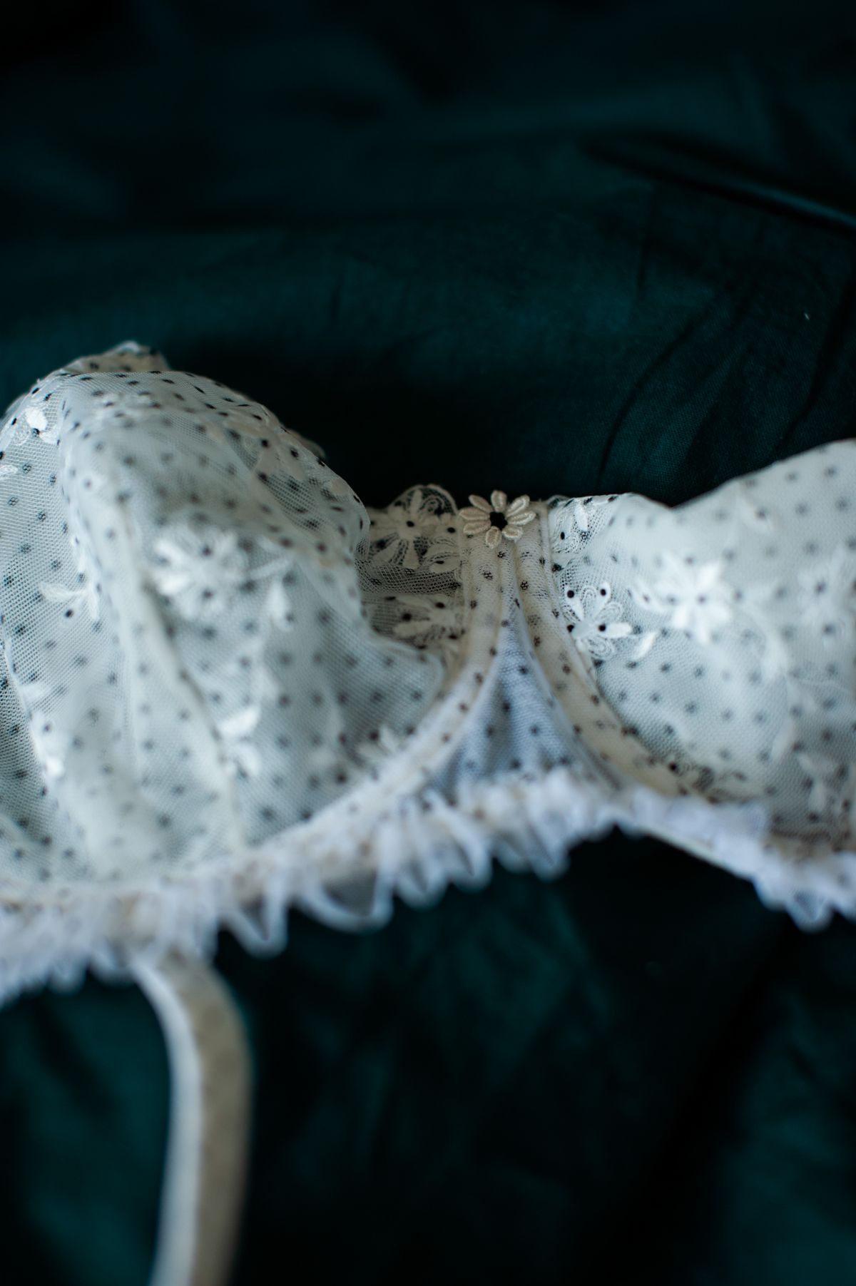 A lace balconette bra laid flat, with the centre gore panel clearly visible between the two cups