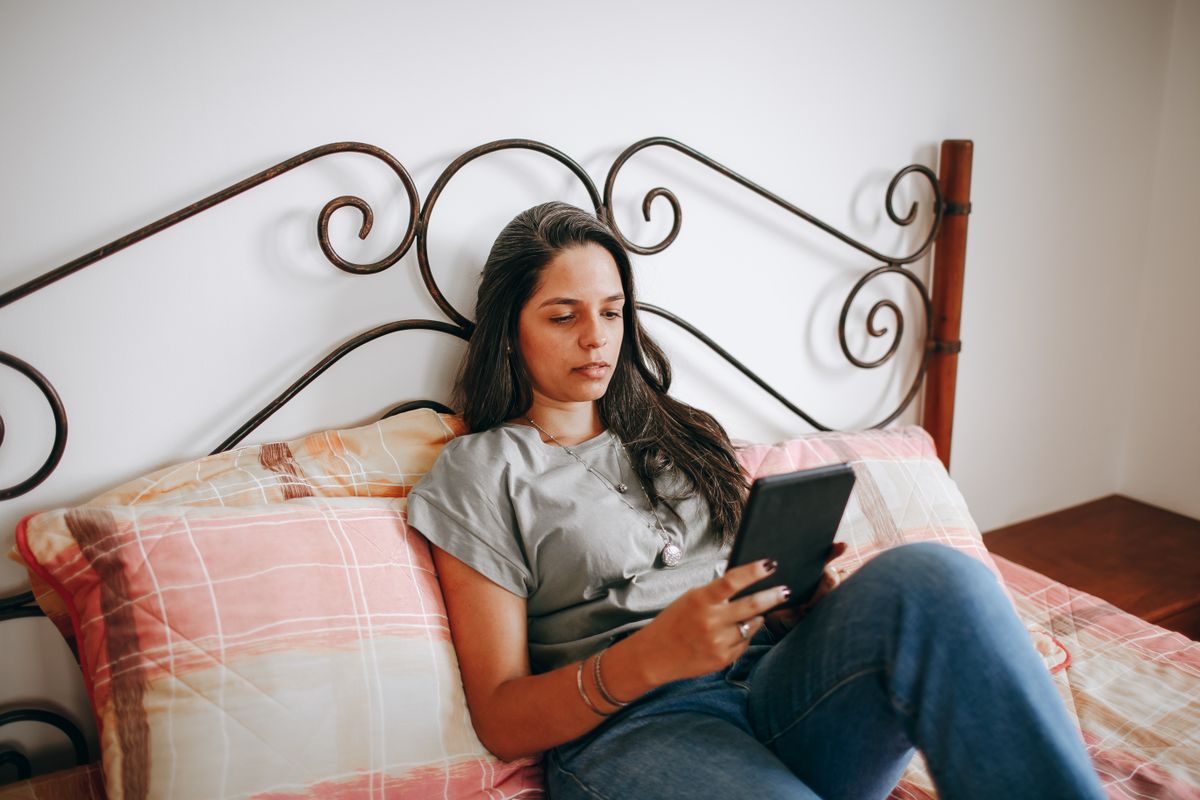 Woman resting comfortably on a bed at home in the evening