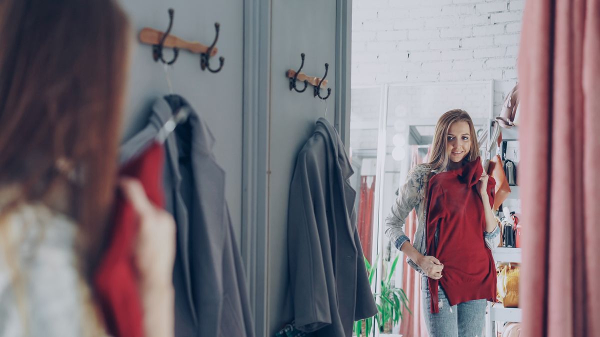 A woman trying on different bra styles in a fitting room