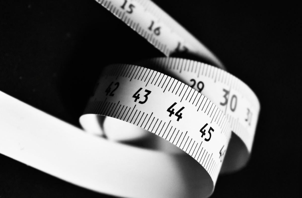 Curved measuring tape marked with numbers, representing bra size chart measurements