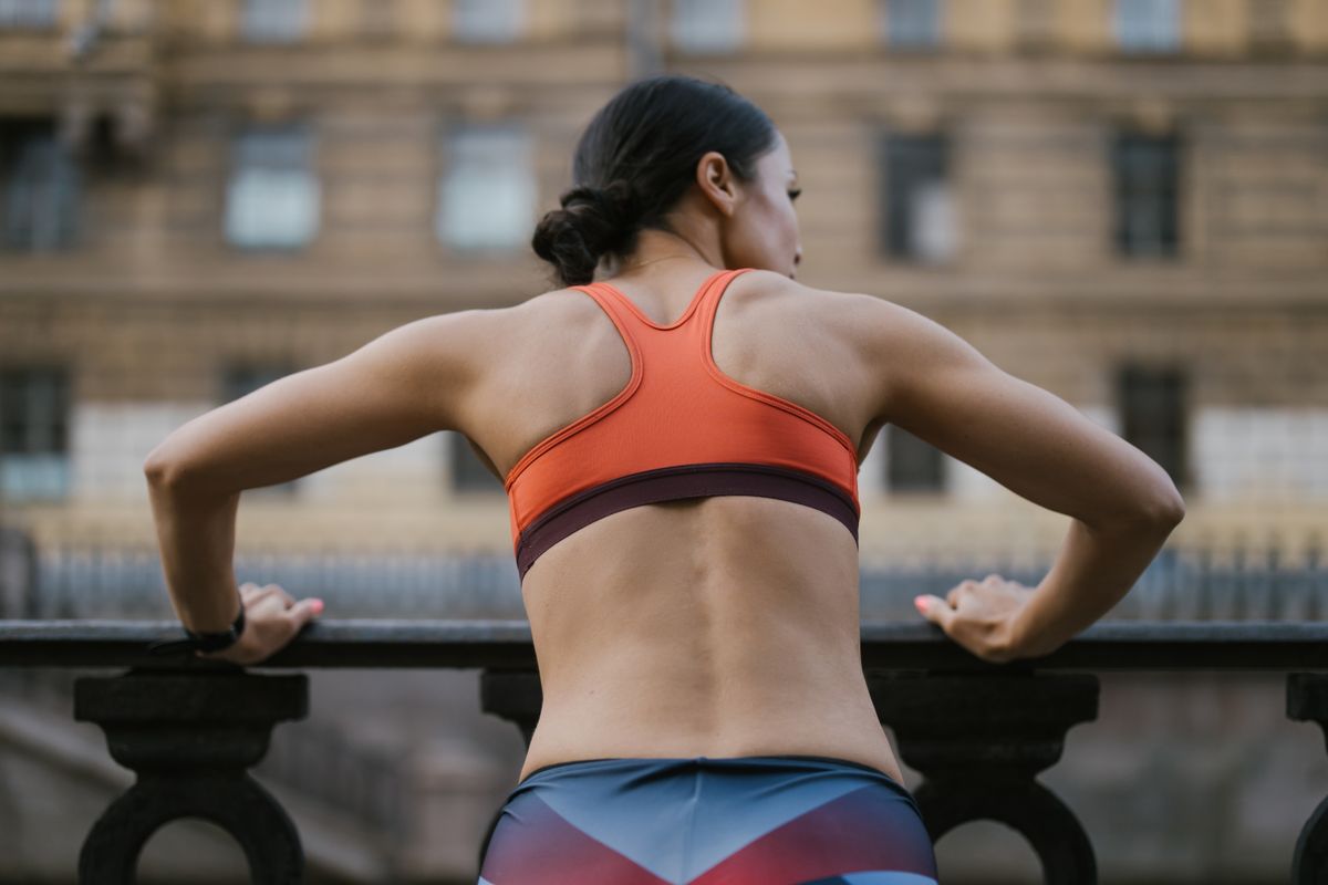 Back view of a woman in a sports bra showing the band sitting level across her ribcage