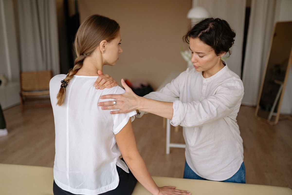 Therapist giving a shoulder massage, suggesting when to seek help for ongoing shoulder pain