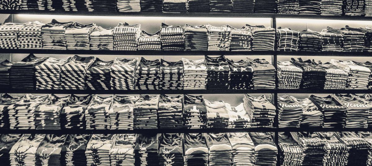 Neatly folded clothing stacked on a shop shelf, ready to try for fit