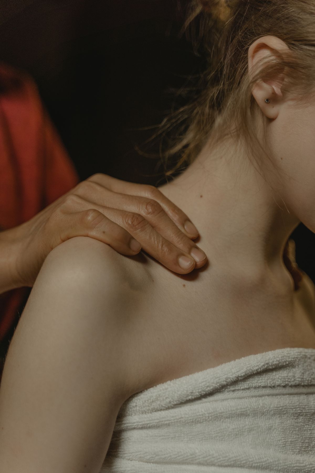 Close-up of a woman's shoulder and neck where bra strap grooves and shoulder indentations form
