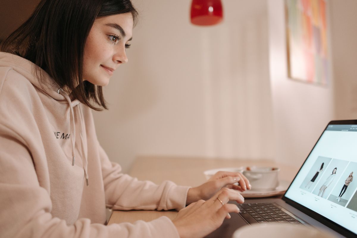 A woman browsing an online clothing store on a laptop to find her bra size