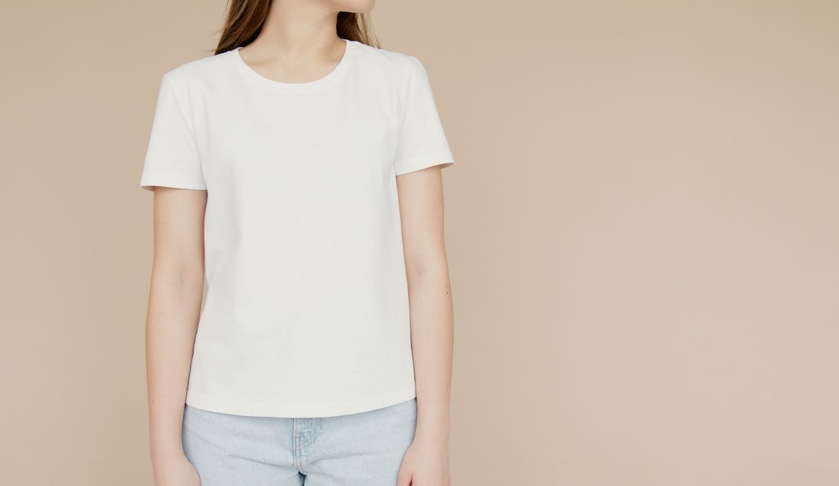 A woman in a simple white t-shirt, showing the everyday look a bra for a small bust gives