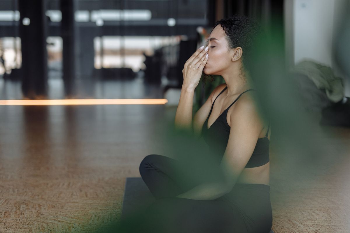 Woman sitting cross-legged in a sports top doing a slow breathing exercise