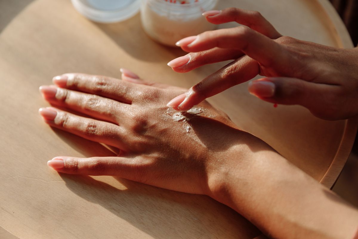 Hands gently massaging moisturiser into the skin to fade bra marks over time
