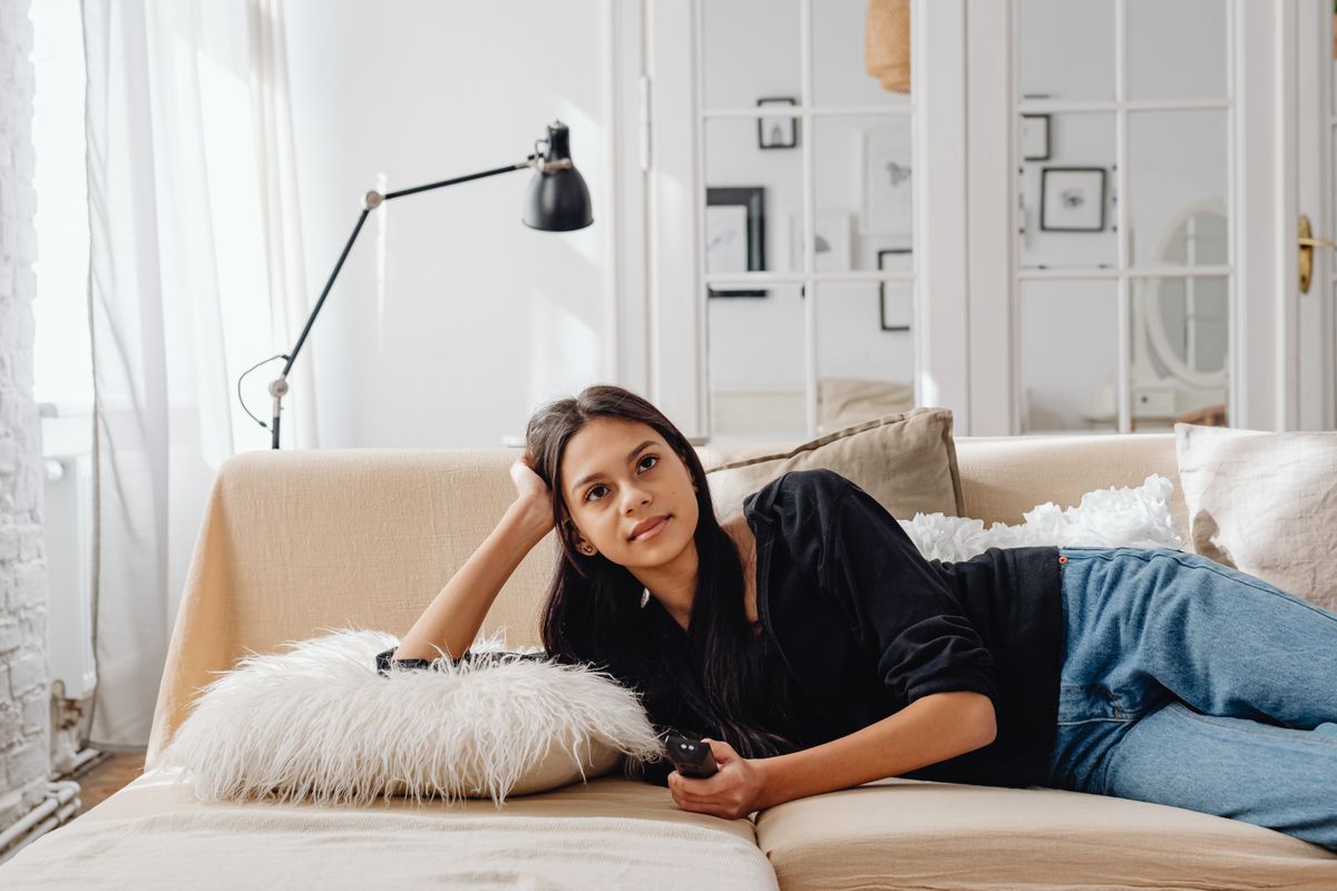 Woman lying comfortably on a sofa at home in relaxed clothing