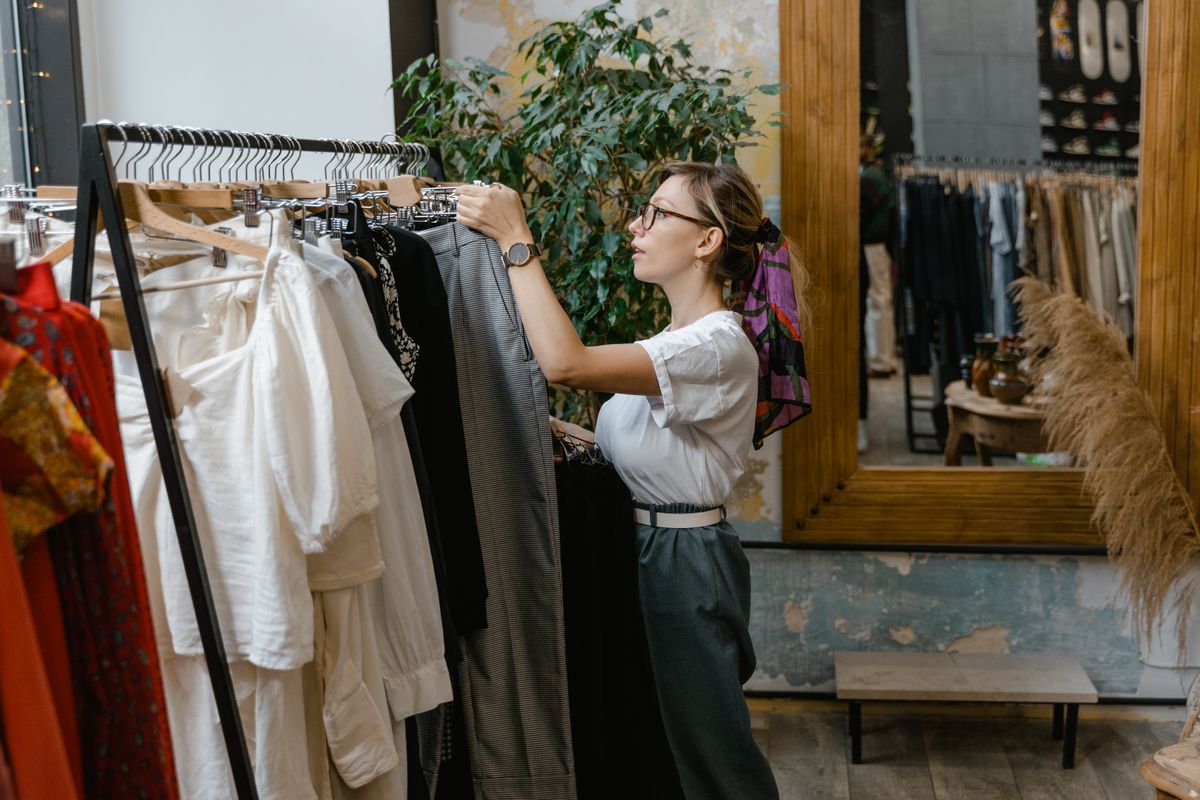 Woman browsing and choosing clothes on a rack in a clothing boutique
