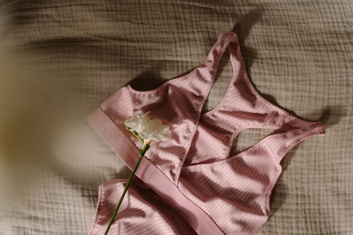 Flat lay of a pink sports bra with a flower, illustrating what a bra size means