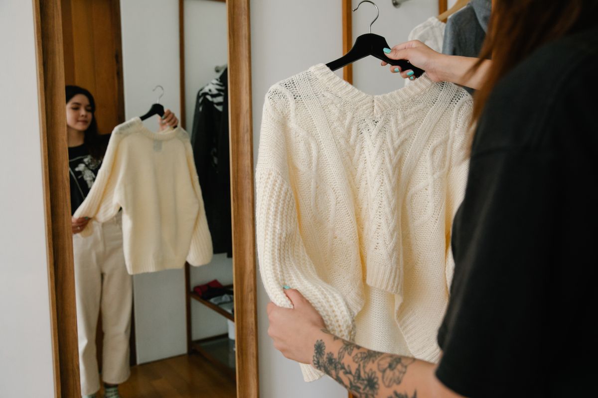 A woman checking her reflection in a mirror while trying on clothing