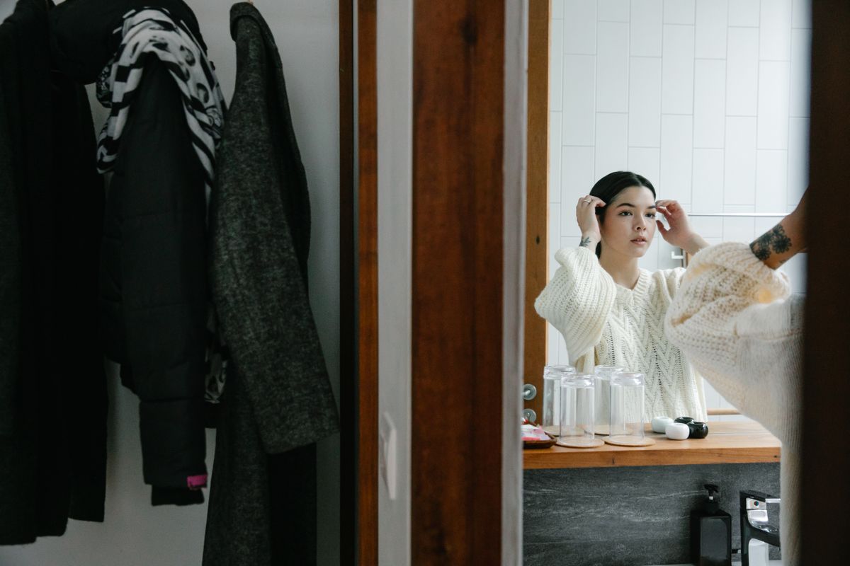 A woman checking her fit in a mirror, the mirror test for a bra band riding up